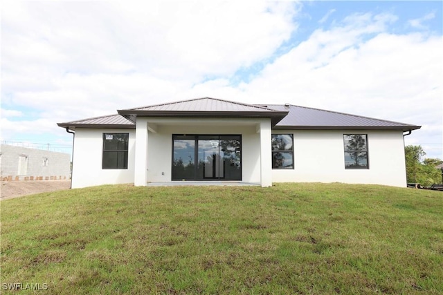 2517 11th St SW, Lehigh Acres, FL 33976 - back of property featuring a standing seam roof, metal roof, a yard, and stucco siding
