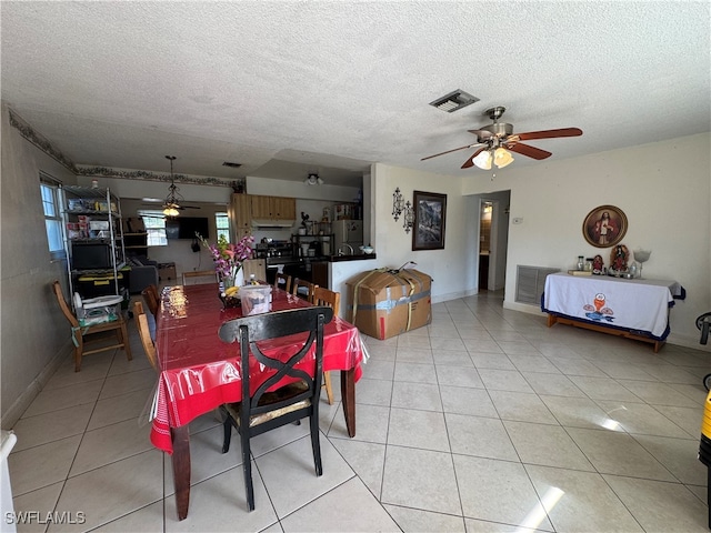 dining room with ceiling fan, light tile patterned floors, and a textured ceiling