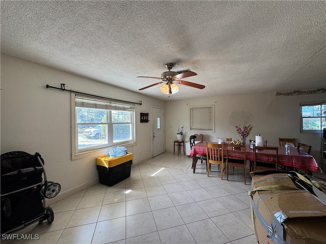 dining room with light tile patterned floors, a textured ceiling, and ceiling fan