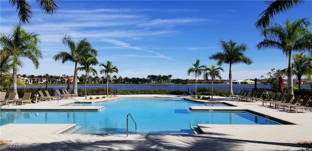 view of pool with a water view and a patio area