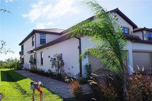 view of home's exterior with a lawn and a garage