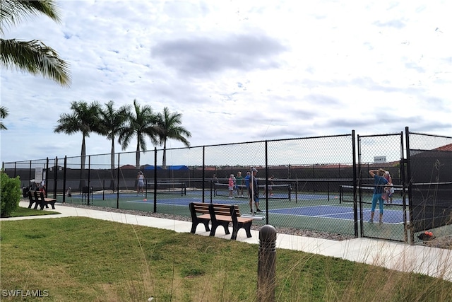 view of tennis court featuring a yard