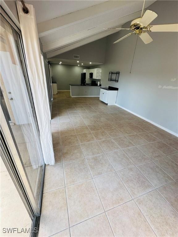 unfurnished living room featuring ceiling fan, light tile patterned floors, and lofted ceiling with beams