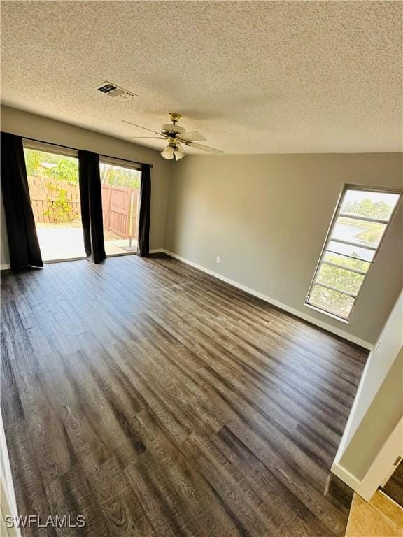 empty room with ceiling fan, dark hardwood / wood-style floors, and a textured ceiling