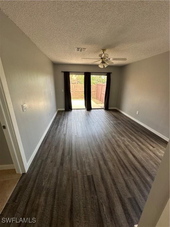 unfurnished room featuring ceiling fan, dark hardwood / wood-style flooring, and a textured ceiling