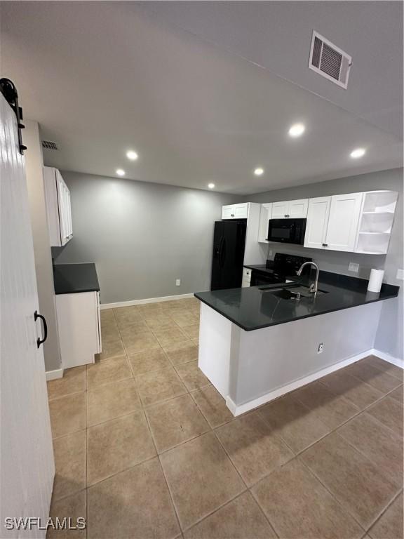 kitchen featuring white cabinets, black appliances, sink, kitchen peninsula, and light tile patterned floors