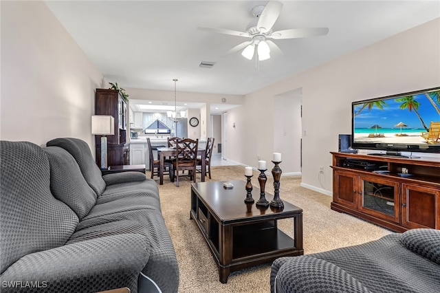 carpeted living room with ceiling fan