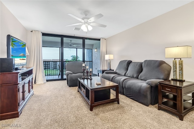 carpeted living room with ceiling fan and expansive windows