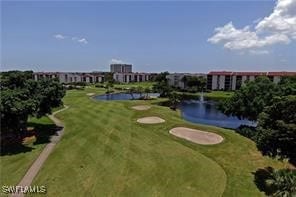 view of home's community with a water view and a yard