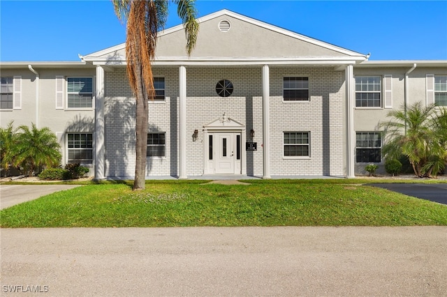 7068 Nantucket Cir Unit 3, North Fort Myers, FL 33917 - view of front of property featuring a front lawn, stucco siding, and brick siding
