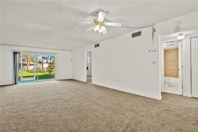 carpeted spare room featuring a textured ceiling and ceiling fan