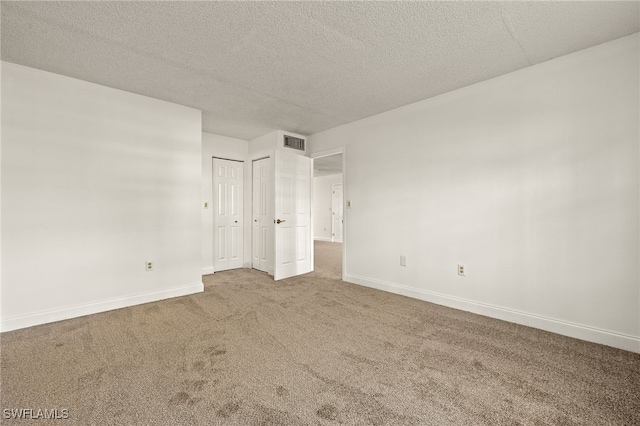 unfurnished bedroom with carpet floors and a textured ceiling