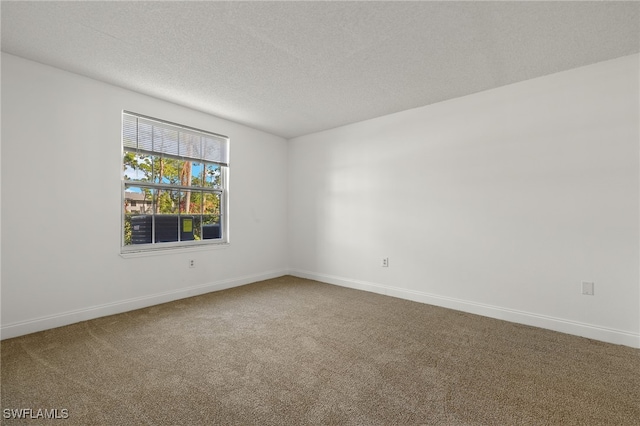 carpeted empty room with a textured ceiling