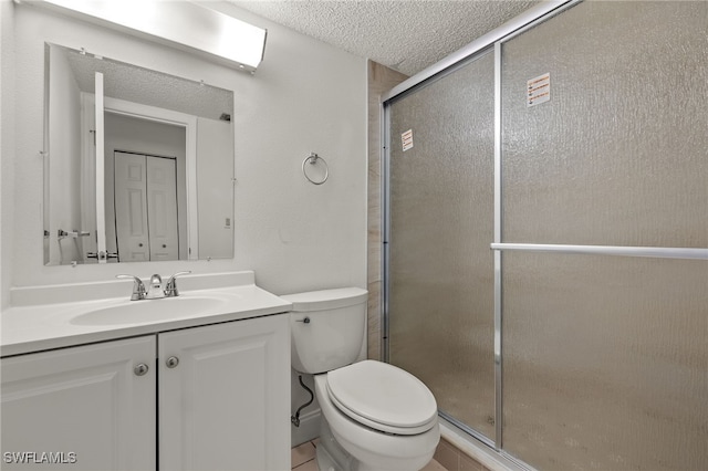 bathroom featuring vanity, a textured ceiling, toilet, and walk in shower