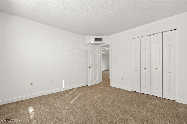 unfurnished bedroom featuring a closet, carpet floors, and a textured ceiling