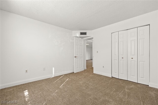 7068 Nantucket Cir Unit 3, North Fort Myers, FL 33917 - unfurnished bedroom with a textured ceiling, carpet flooring, and a closet