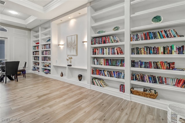 interior space featuring crown molding, built in features, and light hardwood / wood-style floors