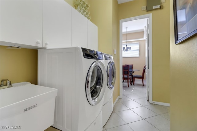 washroom with cabinets, washing machine and clothes dryer, sink, light tile patterned flooring, and a chandelier