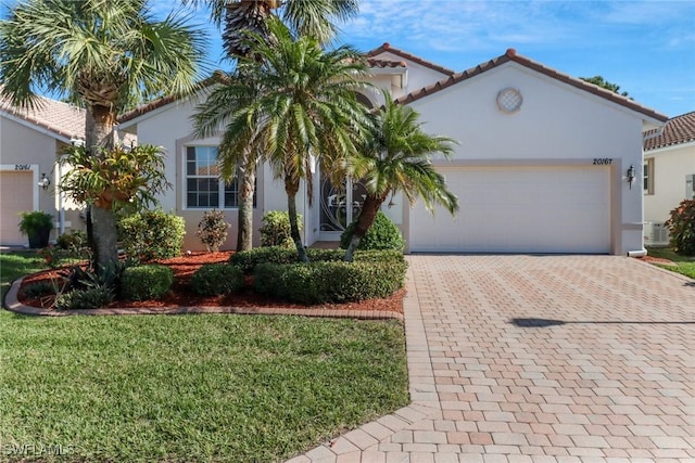 mediterranean / spanish home featuring a front lawn and a garage