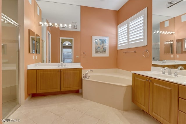 bathroom featuring plus walk in shower, vanity, and tile patterned flooring