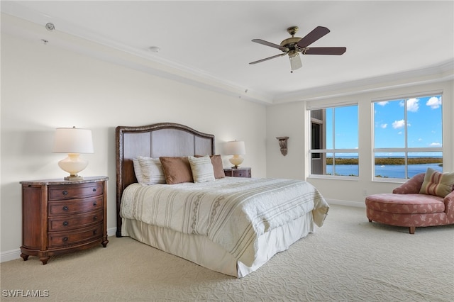 bedroom with ceiling fan, crown molding, a water view, and light colored carpet