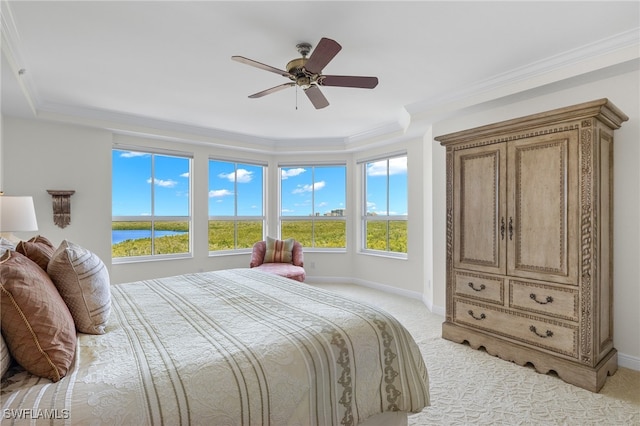 bedroom featuring a water view, light colored carpet, and multiple windows