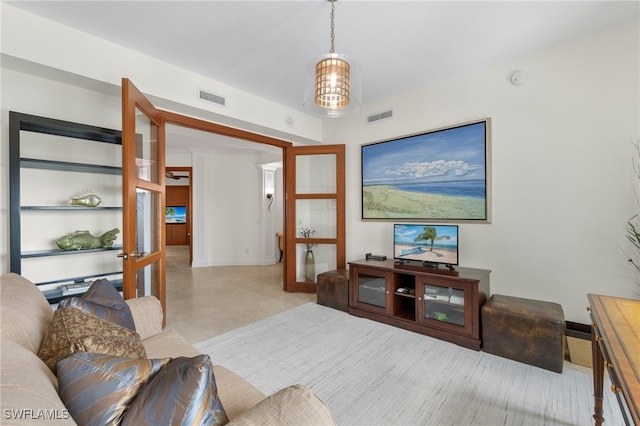 living room featuring french doors and a chandelier