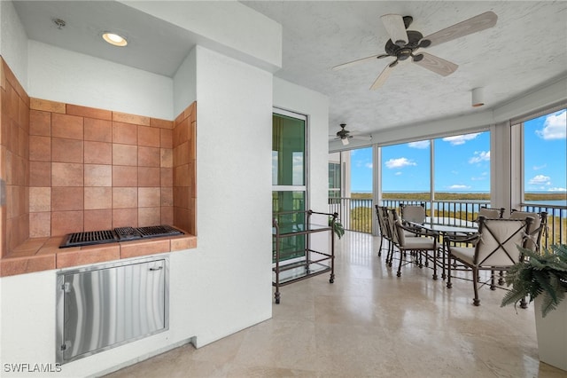 interior space featuring a textured ceiling, a water view, and ceiling fan