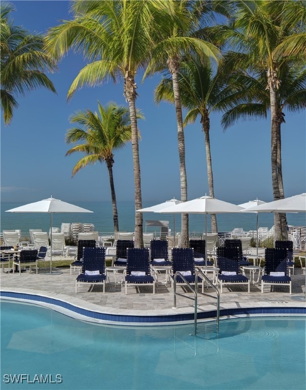 view of swimming pool with a patio area and a water view