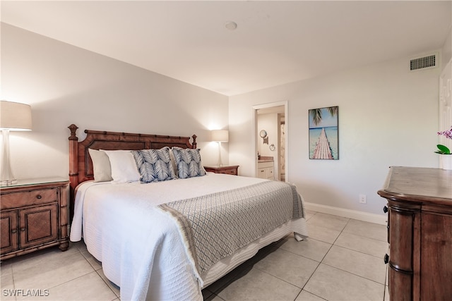 bedroom with ensuite bathroom and light tile patterned flooring