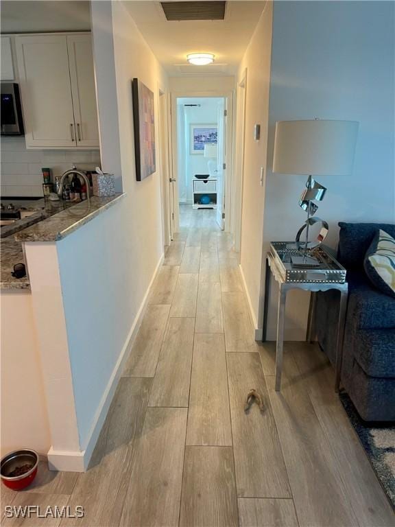 hallway with light hardwood / wood-style floors