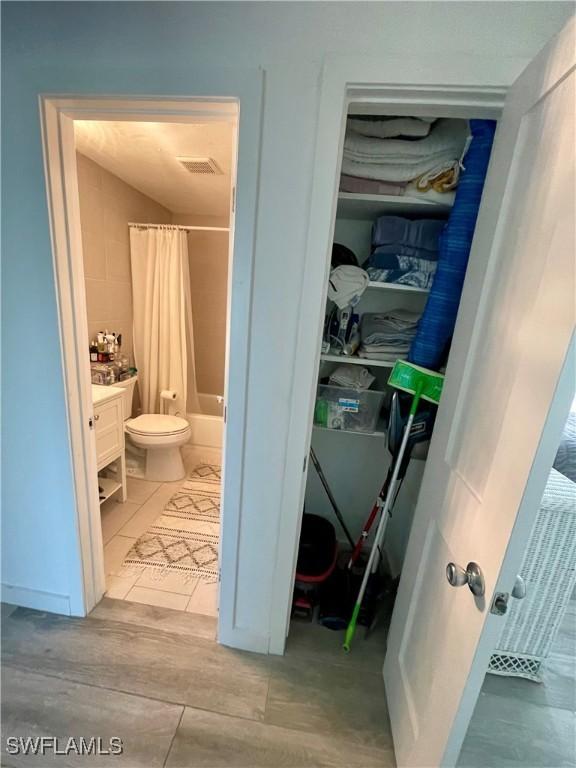 full bathroom featuring shower / tub combo, vanity, and toilet