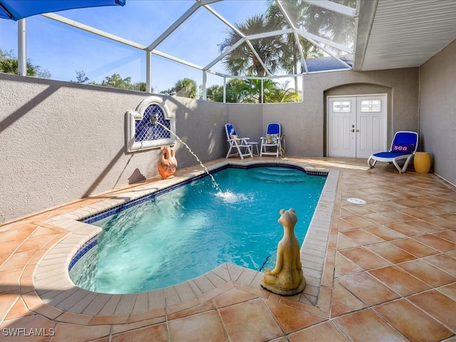 view of pool featuring pool water feature, a patio area, and a lanai