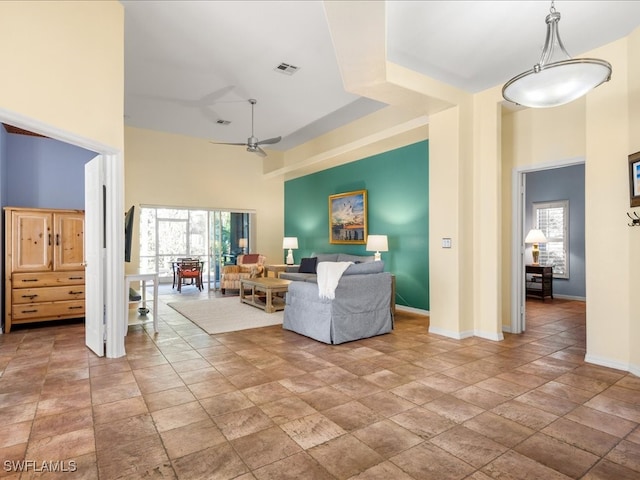 living room with ceiling fan and a high ceiling