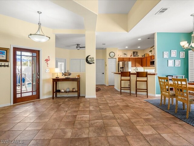 foyer entrance featuring ceiling fan with notable chandelier