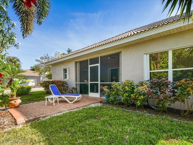 rear view of property featuring a patio area and a lawn