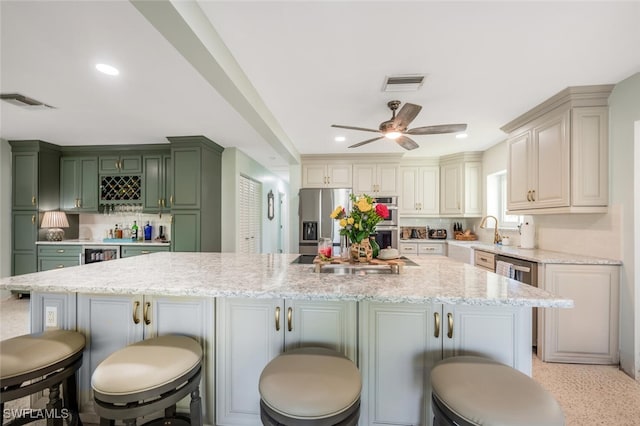 kitchen with light stone counters, stainless steel appliances, a kitchen breakfast bar, and a kitchen island