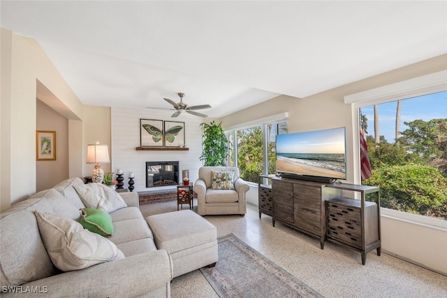 living room with ceiling fan and a large fireplace