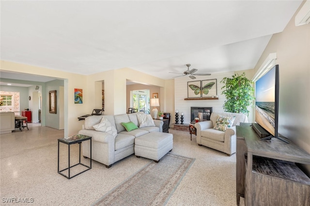 living room with ceiling fan, plenty of natural light, and a fireplace