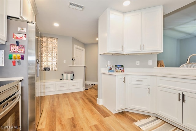 kitchen featuring light wood-type flooring, white cabinetry, sink, and appliances with stainless steel finishes