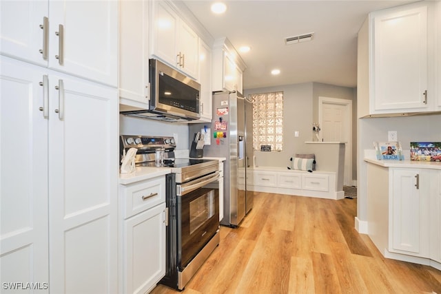 kitchen featuring white cabinets, stainless steel appliances, and light hardwood / wood-style floors