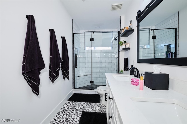 bathroom with tile patterned flooring, vanity, a shower with shower door, and toilet