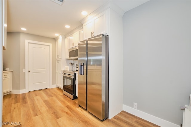 kitchen with light hardwood / wood-style floors, white cabinetry, and appliances with stainless steel finishes