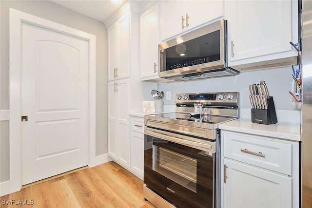 kitchen featuring white cabinets, stainless steel appliances, and light hardwood / wood-style flooring