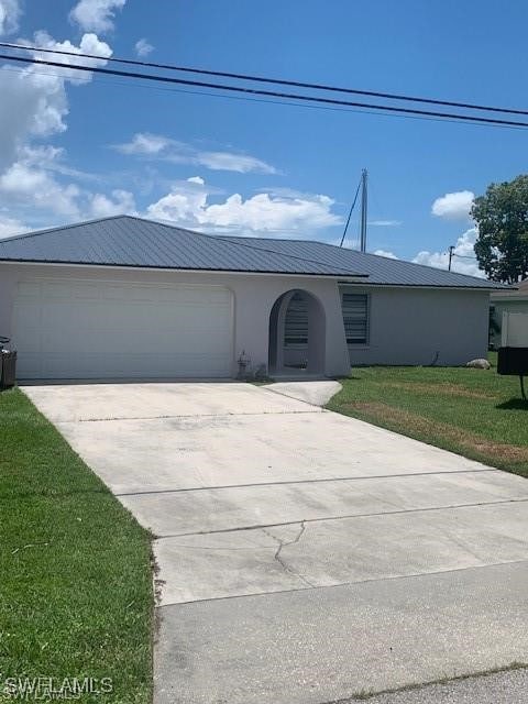 single story home with a front yard and a garage