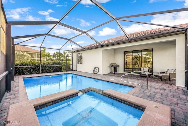 view of swimming pool with glass enclosure, an in ground hot tub, and a patio