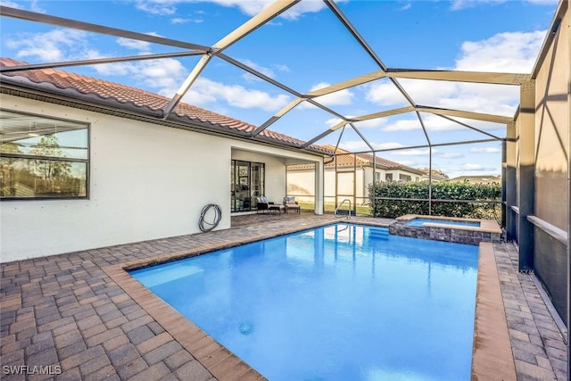 view of swimming pool with an in ground hot tub, glass enclosure, and a patio area