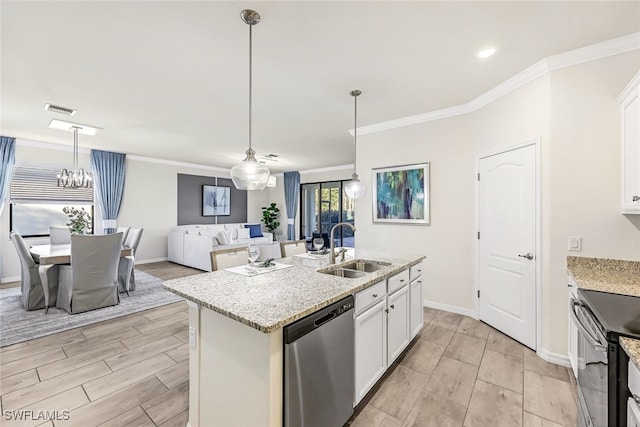 kitchen with white cabinets, appliances with stainless steel finishes, a center island with sink, and sink