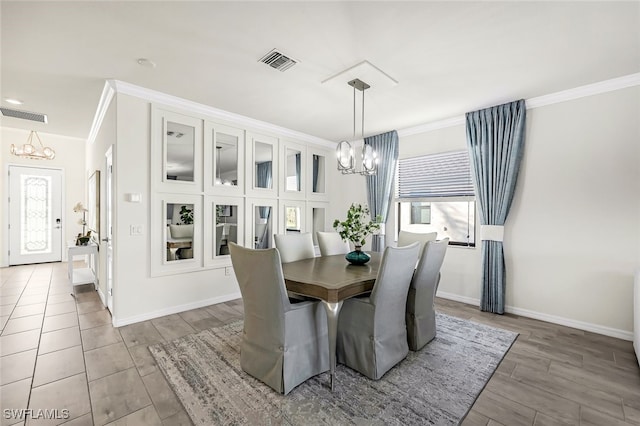 dining room with light hardwood / wood-style floors, an inviting chandelier, and crown molding