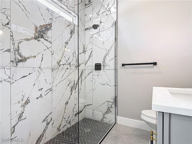 bathroom with a tile shower, vanity, and toilet